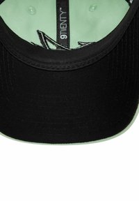 Czarna czapka z miętowo zielonym spodem, materiałowym daszkiem oraz widocznym szwem. Wewnątrz metka z napisem "9TWENTY". Gładka struktura bez widocznych wzorów.