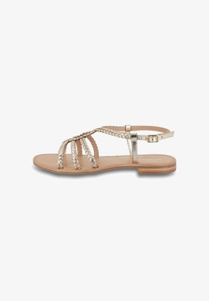 Sandalias metálicas doradas con tiras trenzadas, que cuentan con una suela plana y una correa de tobillo ajustable. Diseño texturizado en las tiras, base neutra.