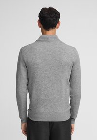 Grauer Langarmpullover mit ribbeligem Kragen und Bündchen, glatter Textur und figurschmeichelndem Design, von hinten betrachtet.