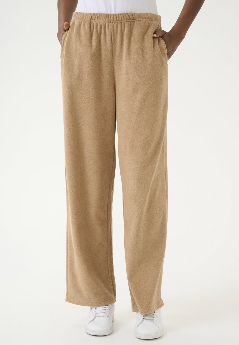 Beige, weiche Stoff-Loungehosen mit einem elastischen Taillenbund und seitlichen Taschen, featuring eine gerade, lockere Passform und gesäumten Bündchen.