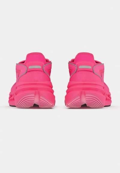 Φωτεινά ροζ αθλητικά παπούτσια με υφή, επένδυση στον γιακά και αντανακλαστικές λεπτομέρειες. Διαθέτουν χοντρή σόλα με ριγωτό σχέδιο.