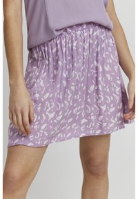 Jupe lilas clair avec un motif abstrait blanc, taille �élastique froncée et tissu fluide. Le design présente une texture douce et une coupe décontractée.