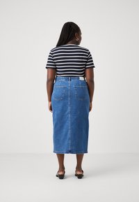 Tume triibuline T-särk, lühikesed varrukad, must denim seelik, kaks tagaolevat taskut, kesk-kalfini ulatuv pikkus, sile tekstuur, mustad avatud varvastega kingad.