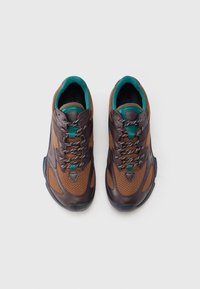 Barna bőr és hálós anyagú sportcipők türkiz színű részletekkel. Kerek orr, texturált felsőrész és kontrasztos fűzők jellemzik. Gumi talp a jobb tapadás érdekében.