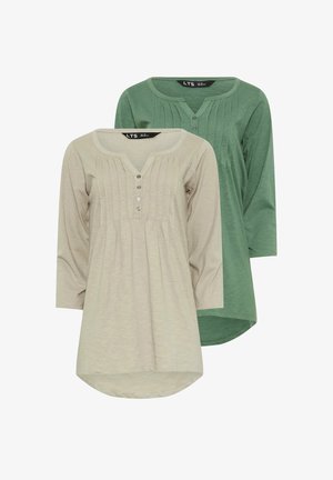 Dwie bluzki z długim rękawem: jedna jasnobeżowa z plisowanym wzorem i pięcioma guzikami, druga jednolita zielona, obie z okrągłymi dekoltami.