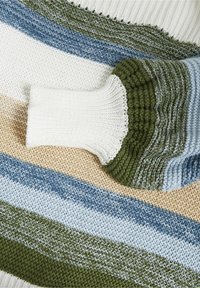 Suéter de punto con rayas horizontales en blanco, beige, azul, verde y azul claro. Presenta puños acanalados y texturas variadas en la tela.