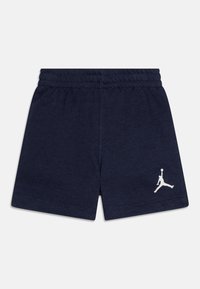 Tumedad sinised lühikesed püksid pehmest kangast, millel on elastne vöökoht ja valge Jumpman logo vasakul alumisel poolel.