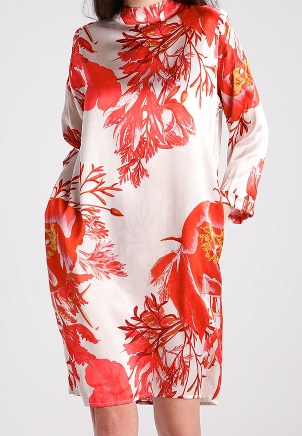 Robe blanche à manches longues avec un col montant présentant de grands motifs floraux et feuilles rouges sur tout le tissu.