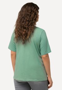 Hellgrünes kurzärmliges T-Shirt mit lockerer Passform, aus einem weichen Stoff gefertigt, mit rundem Ausschnitt und schlichtem Design.