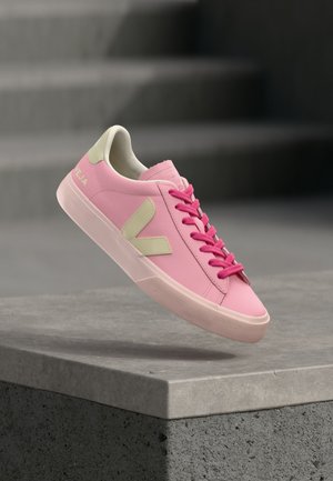 Ροζ δερμάτινα αθλητικά παπούτσια με αντίθετες κρεμ λεπτομέρειες, επίπεδα ροζ κορδόνια, υφασμένο καουτσούκ σόλα και λογότυπο στο πλάι.
