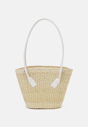 Sac en paille tissée dans des tons naturels, avec une large poignée en tissu blanc et deux accents en cuir blanc sur les côtés.