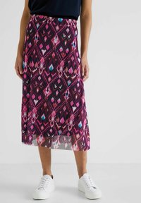 Midi-kjol med ett livfullt geometriskt mönster i lila, rosa och turkos, tillverkad av lätt tyg med en flödande form.