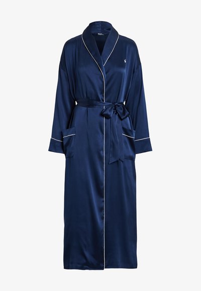 Accappatoio in satin navy con colletto a scialle, piping bianco a contrasto, tasche frontali e cintura. Maniche lunghe e superficie liscia.
