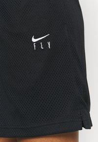 Černé sportovní šortky z prodyšné síťoviny mají vyšívané bílé logo "Nike" a nápis "FLY". Jsou opatřeny bočními rozparky pro lepší větrání a pohodlný pohyb.