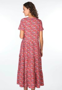 Blumenmusterkleid mit kurzen Ärmeln; roter Grund mit bunten kleinen Blumen. Ausgestellte Form mit gestuftem Rock und V-Ausschnitt.