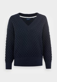 Marinblå stickad tröja med ett strukturerat diamantsmönster, bred V-hals och ribbade ärmslut och nederkant. Tillverkad av mjukt, tjockt material.