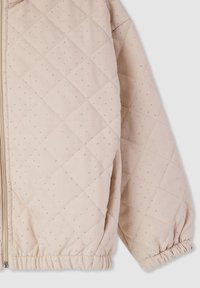 Giubbotto trapuntato beige chiaro con pattern a rombi, adornato con piccole macchie argento. Caratterizzato da polsini elasticizzati e chiusura a zip.