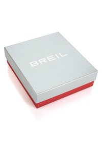 Silver and red box with a matte finish, featuring the word "BREIL" in bold white lettering on the top. Square shape with a smooth texture.