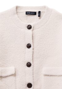Crème kleurige wollen cardigan met een ronde hals, gestructureerde stof en vier donkerbruine knopen. Bevat twee voorzakken.