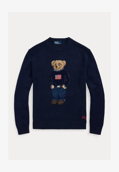 Navy sweater with knitted teddy bear wearing jeans and a sweater with an American flag, ribbed cuffs, and "RL" initials on hem.
