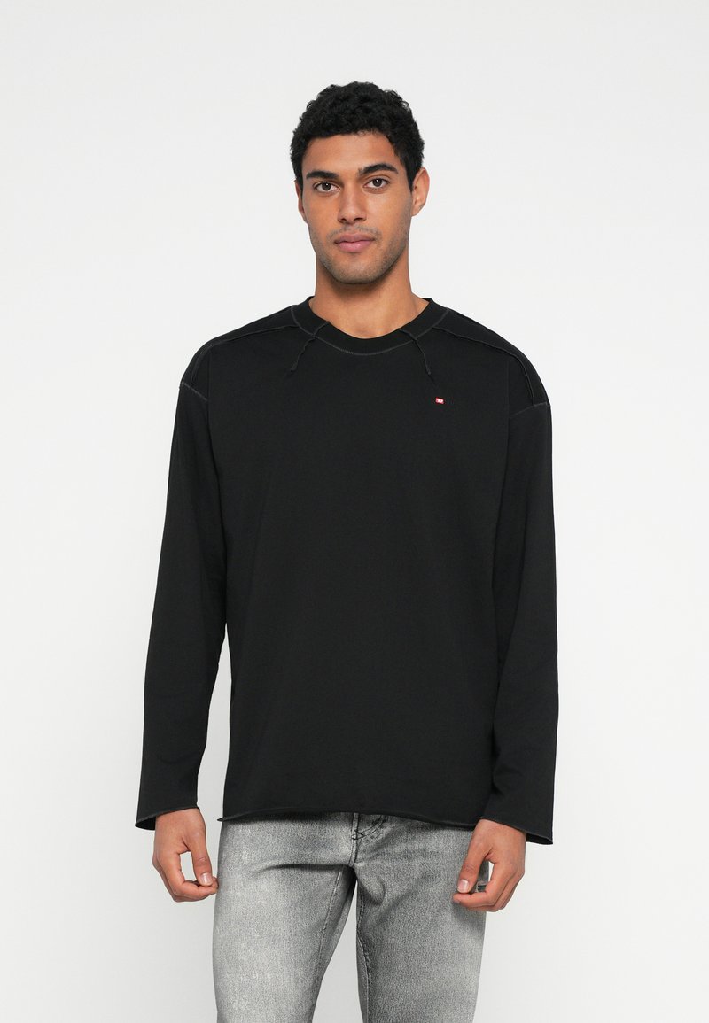 Juoda ilgomis rankovėmis palaidinė su apvalia iškirpte, subtiliomis siuvimo detalėmis ir mažu logotipu ant krūtinės. Pagaminta iš minkštos medžiagos.