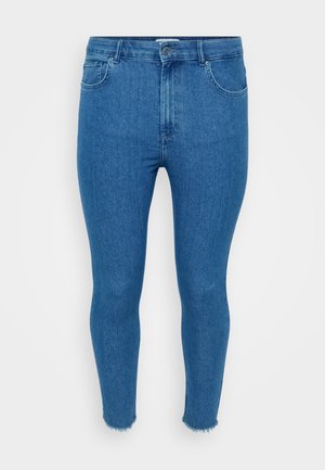 Blue denim skinny jeans with a high waist, featuring a button closure, five pockets, and raw hem detailing at the ankle.