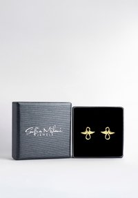 Goldfarbene Ohrringe in Unendlichkeit-Form mit Flügelakzenten, präsentiert in einer schwarzen Samtbox mit strukturiertem grauen Äußeren.