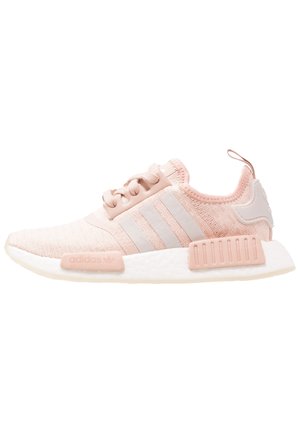 Jasnoróżowe sneakersy Adidas NMD z dzianą cholewką, trzema tonowanymi paskami, wiązaniem na sznurówki, białą wyściełaną podeszwą i pętelką na pięcie.