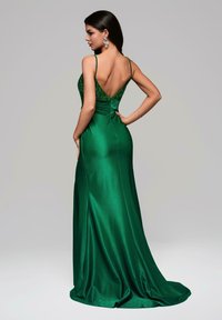 Robe de soirée en satin vert avec un corsage ajusté et un dos en V. Détails en dentelle complexes sur la partie supérieure, jupe fluide et fente sur le côté.