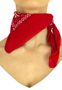 Foulard de style bandana rouge en tissu léger, avec un motif paisley blanc sur les bords et une forme triangulaire. Noué autour du cou.