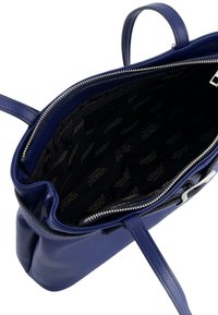 Blauen Lederhandtasche mit einem Reißverschluss, ausgestattet mit einem dunklen Stofffutter, das mit "VENEZIA" geprägt ist, sowie robusten Tragegriffen.