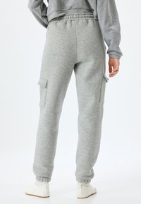 Grijze sweatpants met een elastische tailleband, taps toelopende boorden en zijzakken. Gemaakt van zachte, gestructureerde stof. Eenvoudig en functioneel ontwerp.