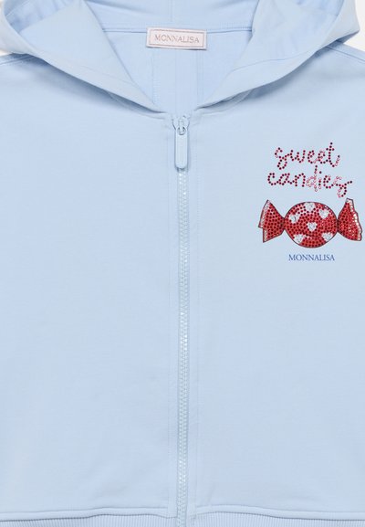 Ανοιχτό μπλε φούτερ με φερμουάρ, με γραφικό καραμέλας από κόκκινες και λευκές παγιέτες. Διαθέτει κουκούλα και ριμπ λεπτομέρειες στο τελείωμα.