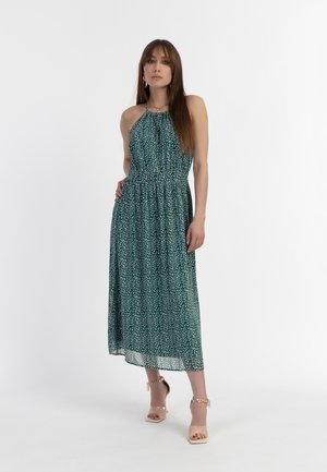 Hihaton, vihreä kukkakuosis midi-mekko, jossa on rypytetty vyötärö ja liehuva hame. Yhdistettynä läpinäkyviin lohkare-korkokenkiin ja kultaisiin yksityiskohtiin.