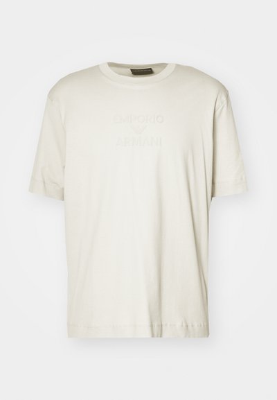 T-shirt de algodão de cor bege-claro com decote redondo e mangas curtas, com logótipo em relevo "Emporio Armani" na parte superior do peito.