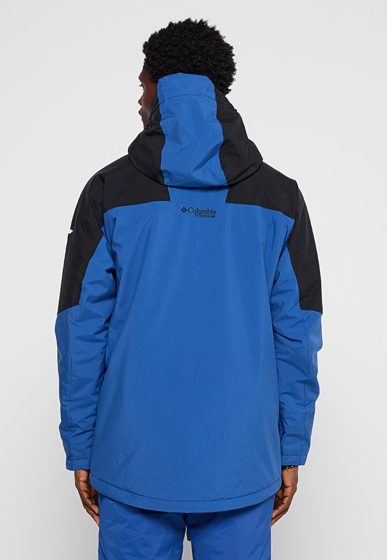 Blaue und schwarze wasserdichte Jacke mit Kapuze, langen Ärmeln und entspannter Passform, mit Branding auf dem oberen Rücken. Glatte Textur.