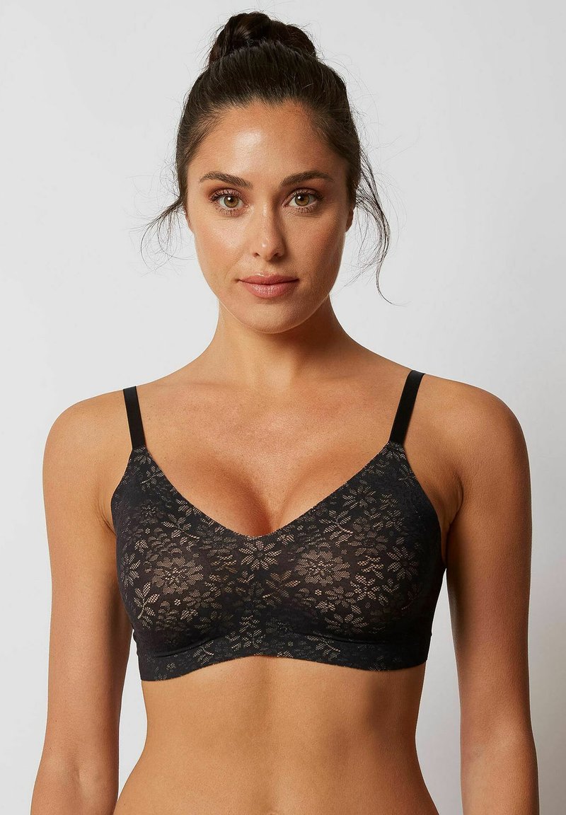 Svart spetsbralette med V-krage, tunna justerbara axelremmar och blommönster genom hela. Mjukt, elastiskt tyg med en slät textur.