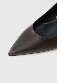 Καφέ δερμάτινη γόβα με μυτερή μύτη και σχεδιασμό με ανοίγματα στα πλαϊνά, με απαλή υφή και μαύρη εσωτερική σόλα.