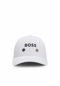 Weißer Baseball-Cap mit „BOSS“ in schwarzer Schrift; verfügt über drei kreisförmige Akzente in Schwarz, Weiß und Braun, die Tennisbällen ähneln.