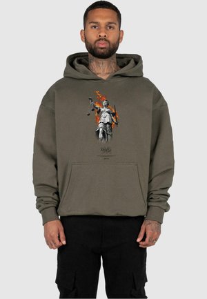 Olivenfarbener Kapuzenpullover aus weichem Material mit einem Frontdruck von Lady Justice inmitten von Flammen, mit Kängurutasche und elastischen Bündchen.