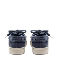 Mornarsko modri platneni čevlji za čoln z bež gumijastimi podplati, ki imajo dve luknji za vezalke, vezanje spredaj in detajle šivanja.