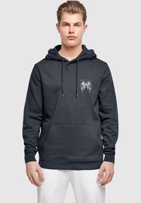 Dunkelgrauer Kapuzenpullover aus weichem Material mit einer Fronttasche und Kordeln. Mit weißem Grafiktext auf der linken Brustseite.