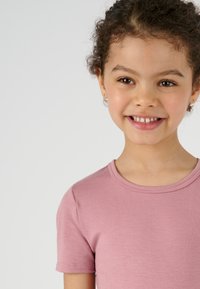 T-shirt di cotone rosa chiaro con maniche corte e scollatura rotonda, caratterizzata da una texture liscia e dettagli di cucitura precisi.