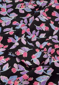Zwarte stof met een bloemenpatroon van roze, lichtblauwe en paarse bladeren en bloemen, met een zachte textuur en variërende vormen.