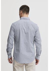 Camicia da uomo a maniche lunghe in tessuto leggero, con strisce verticali blu e bianche, polsini con bottoni e un design classico del collo.