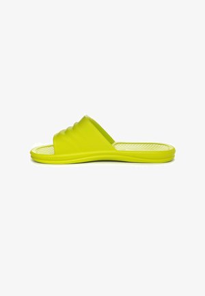 Pantofole verdi con una tomaia texturizzata, design a banda larga e suola resistente. Leggere e flessibili per l'uso casual. Motivo a nido d'ape sulla soletta.