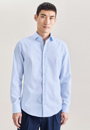 Hellblaues Hemd mit Knöpfen aus glattem Stoff, das ein enganliegendes Design, lange Ärmel und weiße Knöpfe an der Vorderseite aufweist.