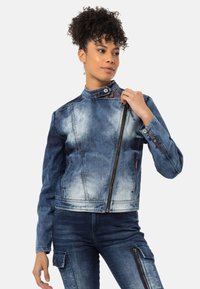 Blaue Jeans-Motorradjacke mit hohem Kragen, asymmetrischem Reißverschluss und kontrastierender heller Waschung. Verfügt über Taschenakzente und strapazierfähige Nähte.