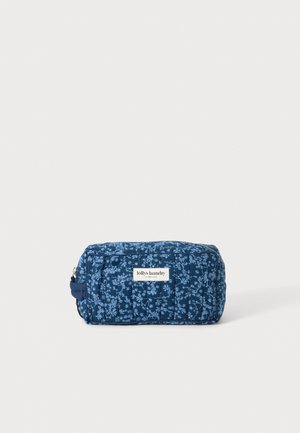 Blå rektangulær stofpose med let blomsterprint og "lollys laundry Copenhagen" mærkat på forsiden, placeret på en ensfarvet baggrund.