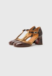 Scarpe T-strap in pelle marrone con punta lucida e pannelli laterali testurizzati in marrone e beige, dotate di tacco a blocco e accenti decorativi.